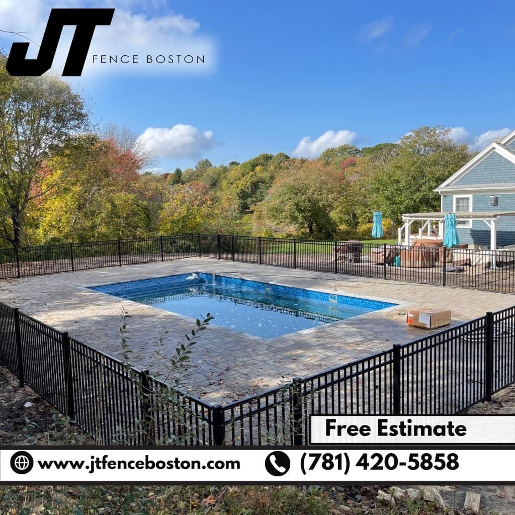 Black metal pool fence enclosing a residential pool with autumn trees — JT Fence Boston pool safety projects