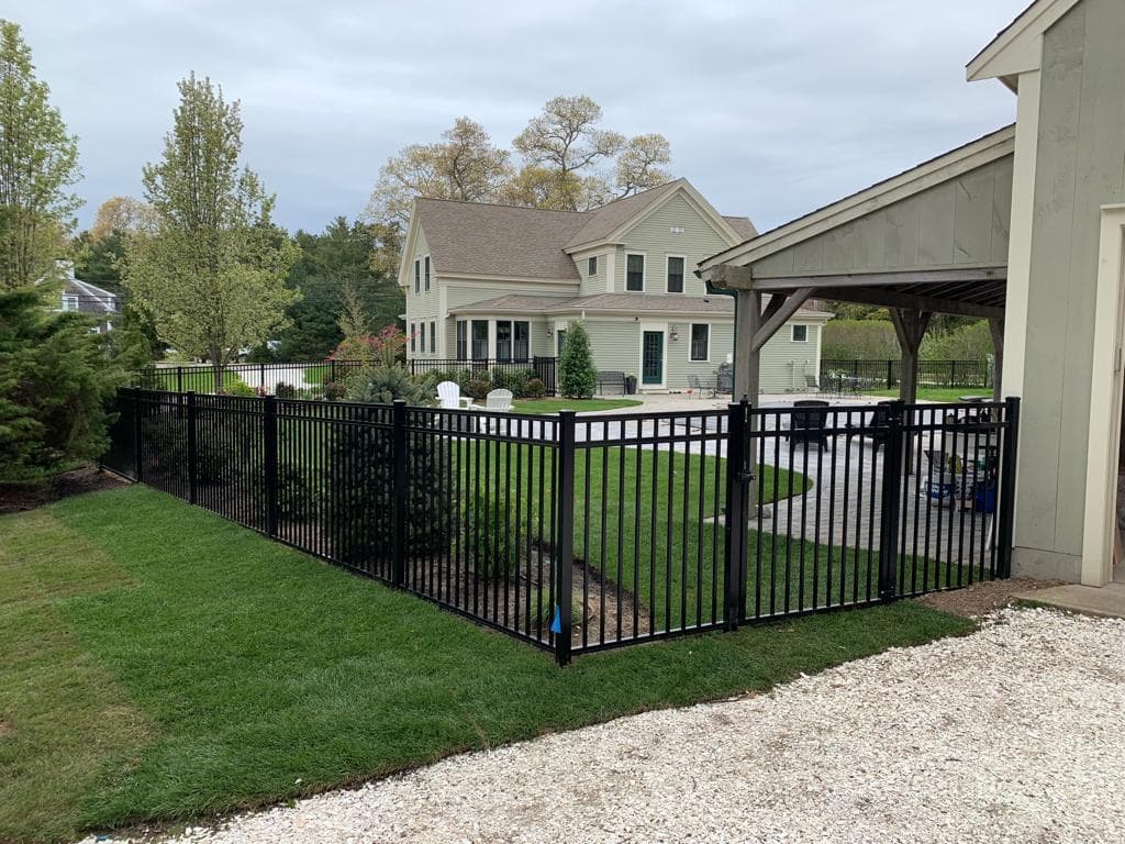 Black aluminum pool fence around backyard pool area near upscale home