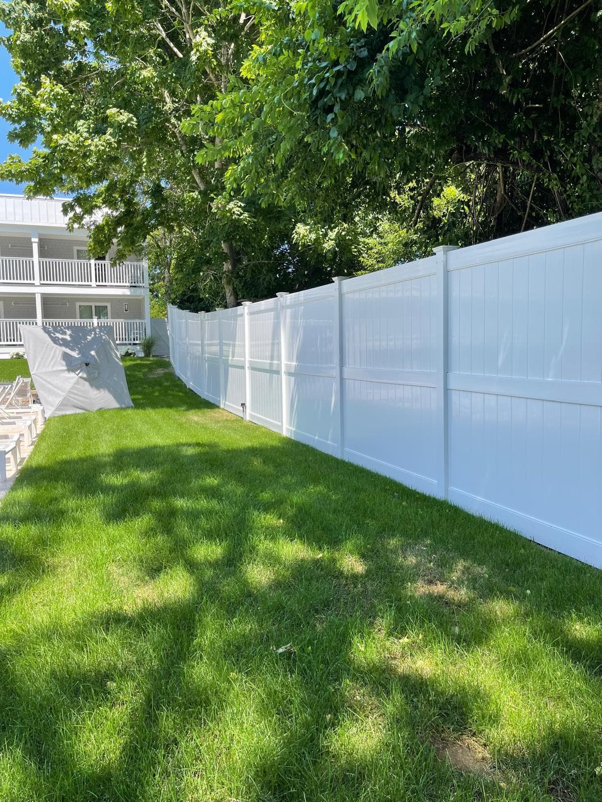 White vinyl privacy fence near residential buildings