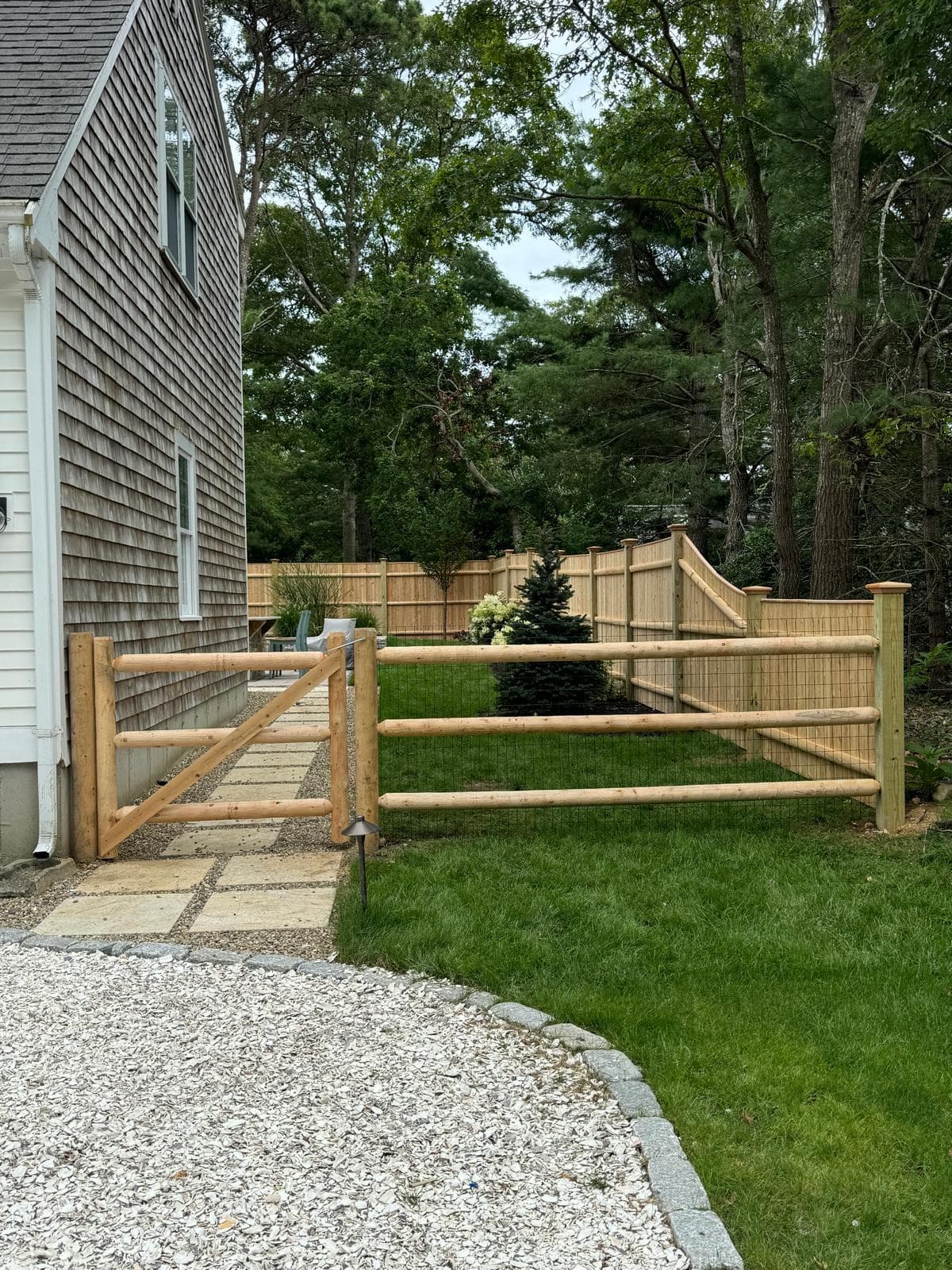 Custom aluminum fence layout following grade changes on a landscaped lot