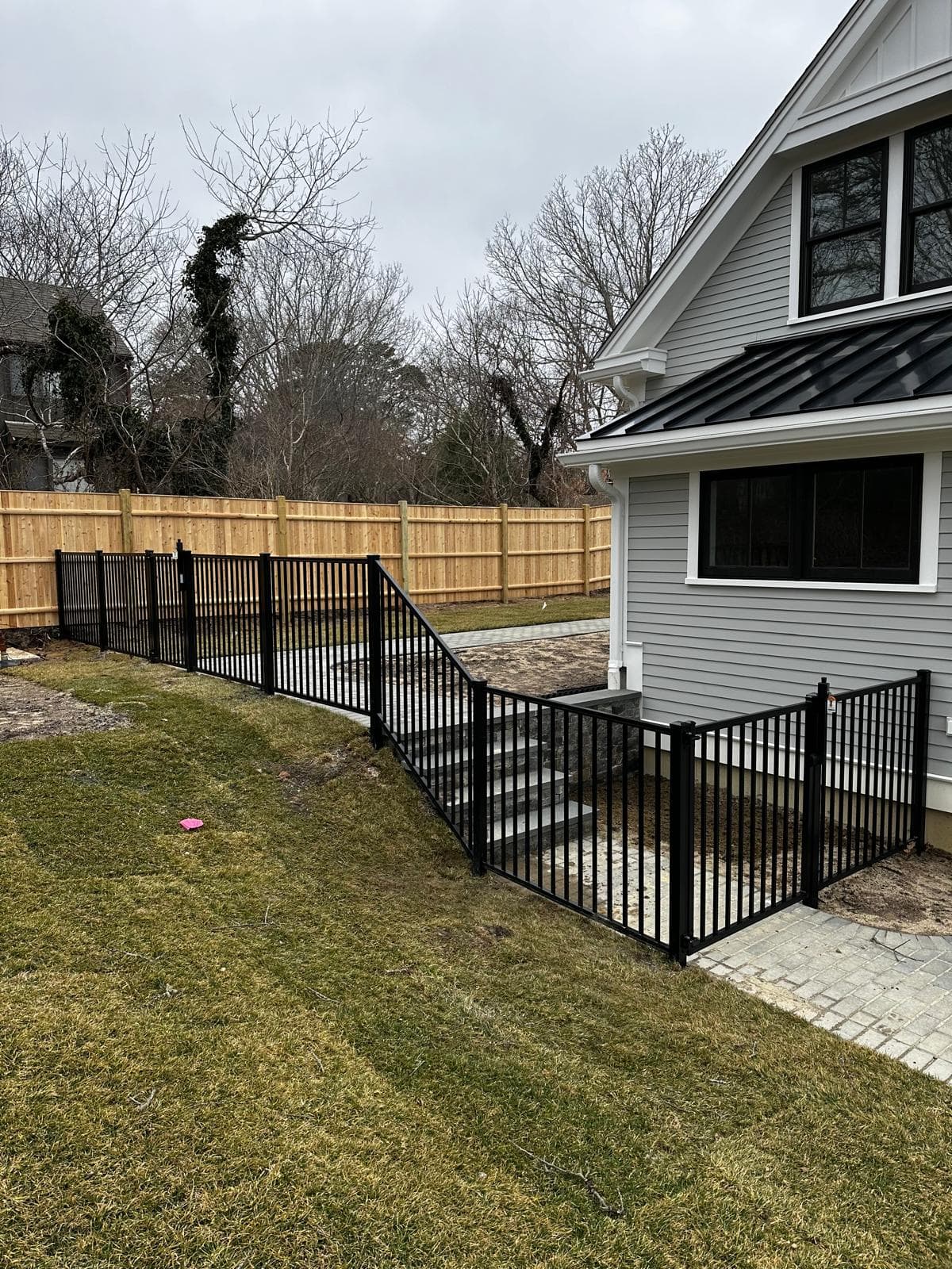 Black aluminum fence around backyard with pet containment visible