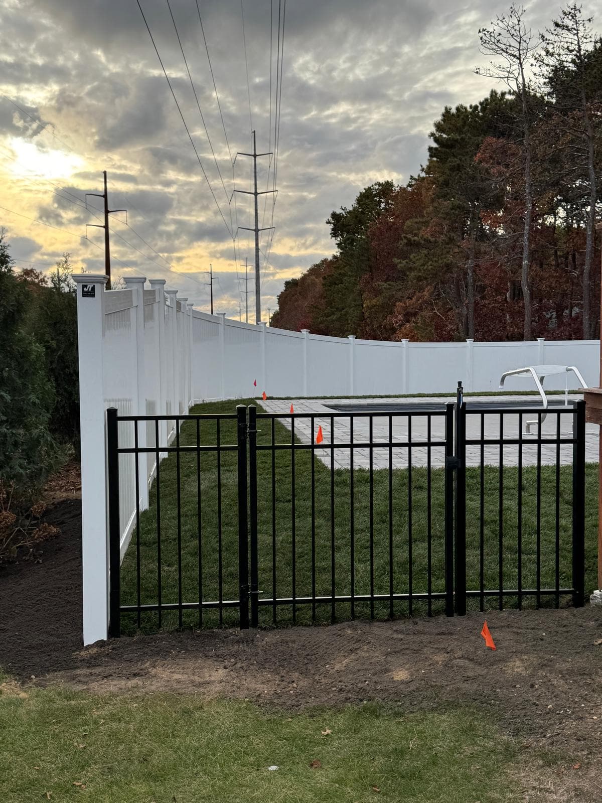 Black aluminum and white vinyl mixed fence installation — complementary materials