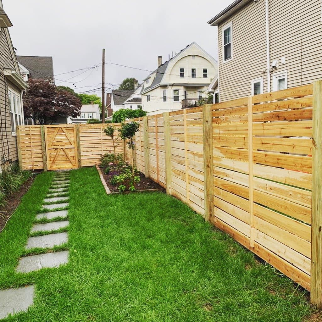 Traditional wood picket or privacy fence along a residential front or side yard, South Shore MA